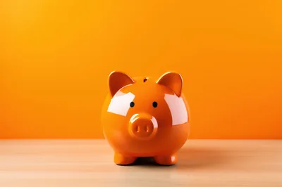 Orange Piggy Bank On Wooden Table