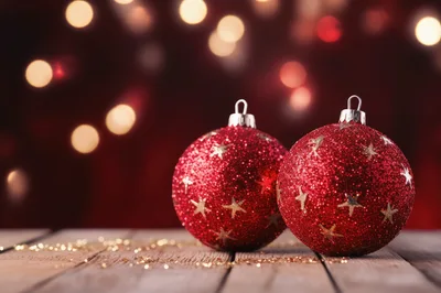 Two Red Glittery Christmas Ornaments On Wooden Table
