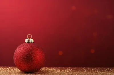 Red Glitter Christmas Ornament on Gold Surface