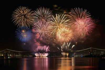 Spectacular Fireworks Display Over A City Bridge At Night