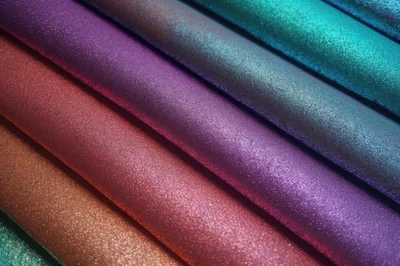 Abstract Background Of Colorful Shimmering Fabric Rolls