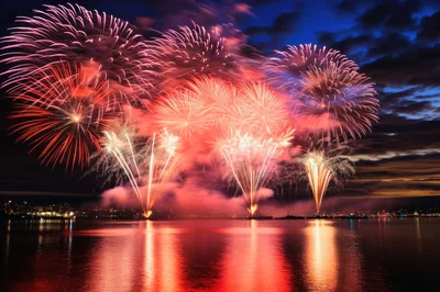 Vibrant Red Fireworks Display Over Harbor Waters