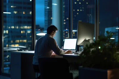 Businessman Working Late In A Modern Office At Night