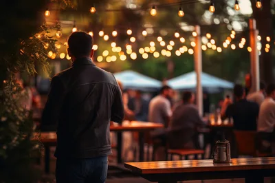 Man Standing Alone at an Outdoor Evening Bar