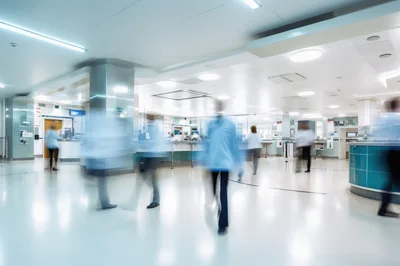 Medical Staff Walking Through Busy Hospital Corridor