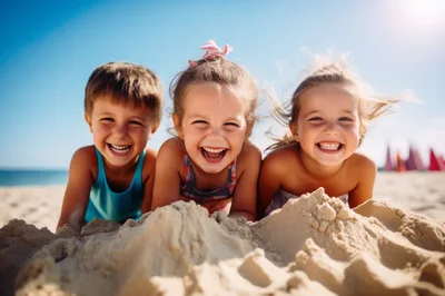 Three Happy Children Playing In The Sand At Beach