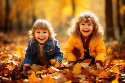 Two Happy Children Playing In Autumn Leaves