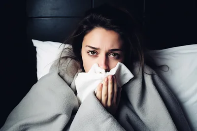 Sick Young Woman Resting In Bed With Blanket