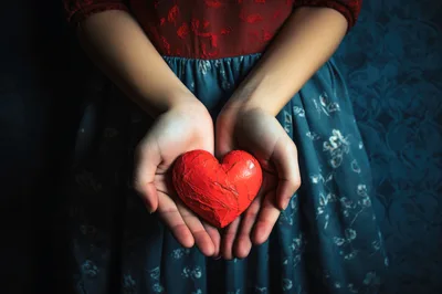 Person Holding A Textured Red Heart In Their Hands