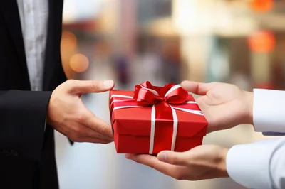 Business Person Handing A Red Gift Box