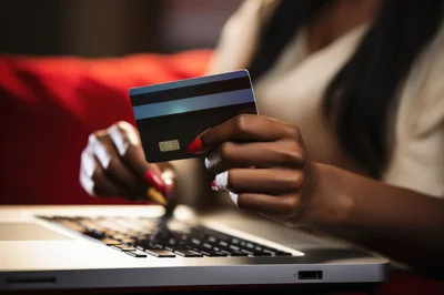 Woman Making Online Purchase With Credit Card On Laptop