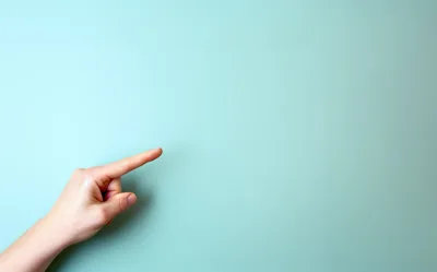 Hand Pointing To The Right On Light Blue Background