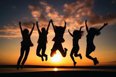 Group Of Friends Jumping Against Sunset Sky