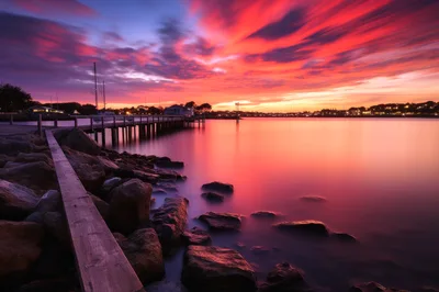 Vibrant Sunset Over A Calm Harbor Pier