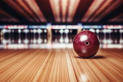 Red Bowling Ball Resting On A Wooden Lane
