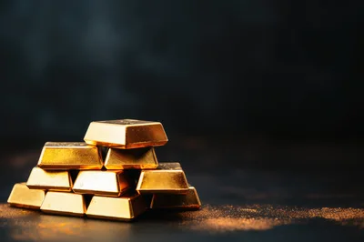 Stack of Shiny Gold Bars on Dark Surface