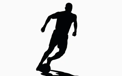 Silhouette Of A Soccer Player Dribbling A Ball