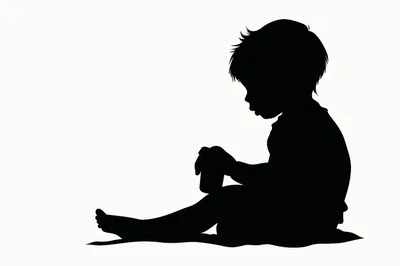Silhouette Of A Toddler Sitting And Playing