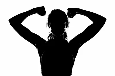 Silhouette Of A Strong Woman Flexing Her Muscles