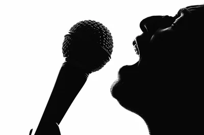 Silhouette Of A Singer Performing Into A Microphone