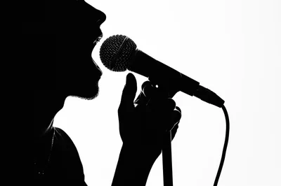 Silhouette Of A Singer Performing With A Microphone