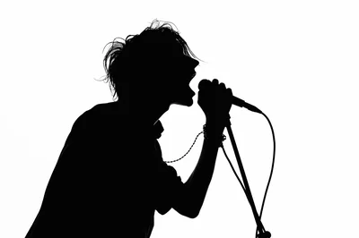 Silhouette Of A Rock Singer Performing Into A Microphone