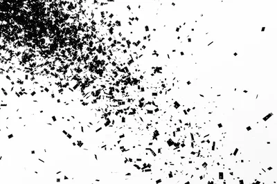 Black Confetti Particles Exploding On White Background