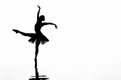 Silhouette Of A Ballerina Dancing On A Reflective Surface