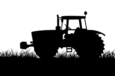 Black Silhouette Of A Farm Tractor In Tall Grass