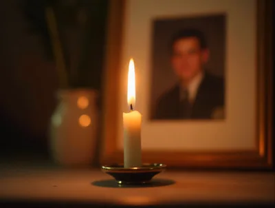 Lit Candle Placed Before A Framed Portrait