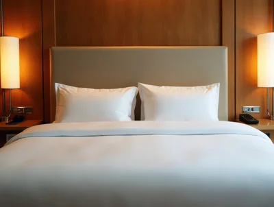 Modern Hotel Bedroom With White Bedding And Warm Lighting