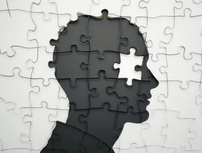Black Human Head Silhouette Formed By Jigsaw Puzzle Pieces