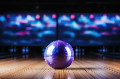 Purple Bowling Ball Resting On A Polished Wooden Lane