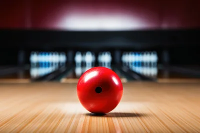 Red Bowling Ball Resting On A Wooden Lane