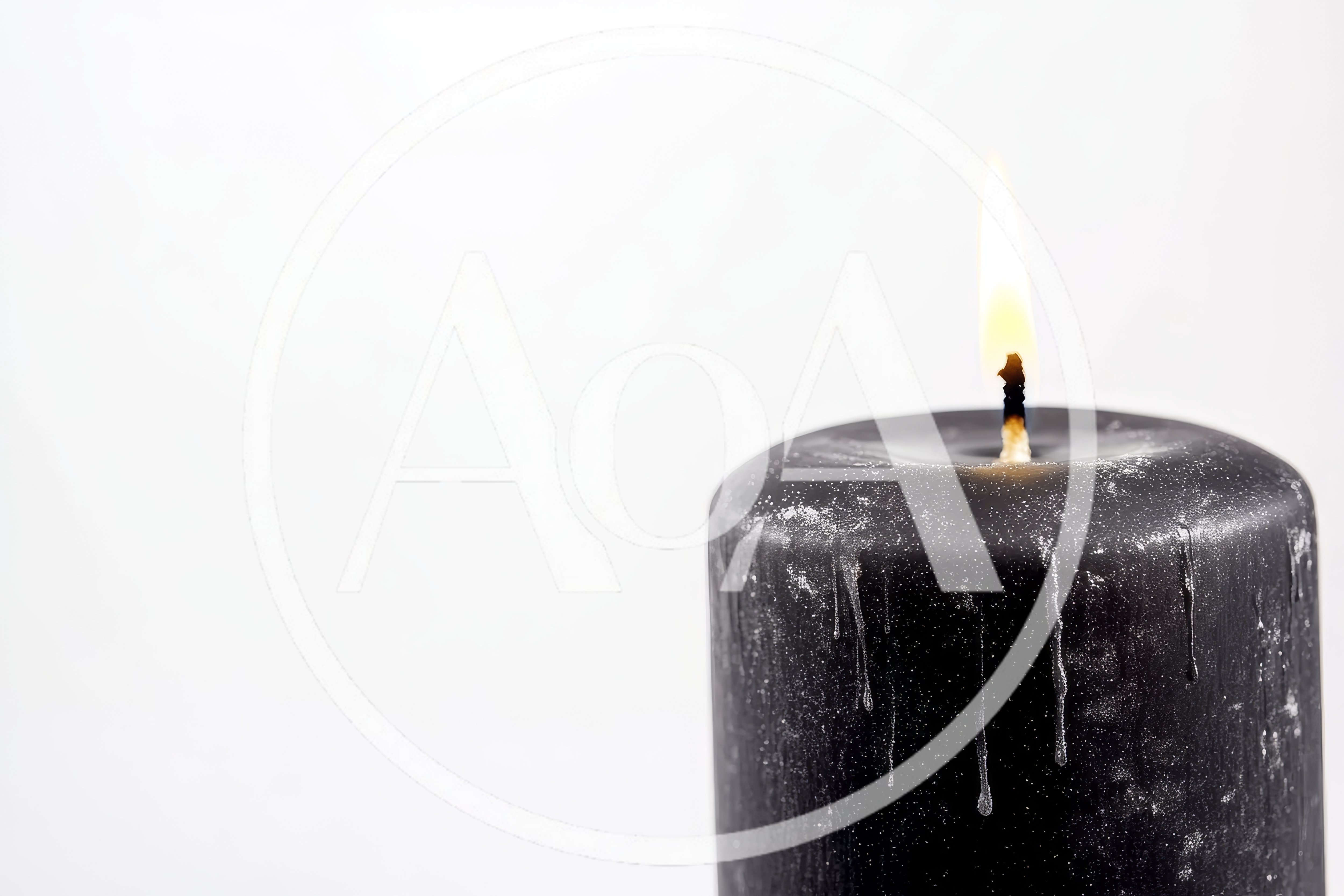 Black Pillar Candle Burning With A Bright Flame