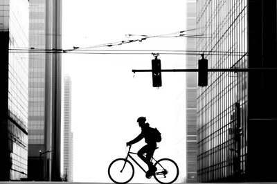 Silhouette Of A Cyclist Riding Through City Skyscrapers