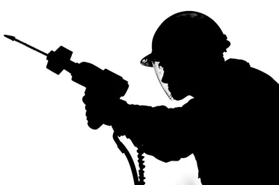 Silhouette Of A Construction Worker Using A Power Drill
