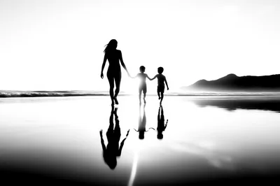 Mother Walking With Two Children On Beach At Sunset