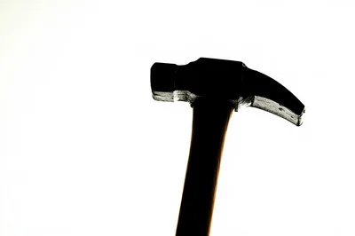 Silhouette Of A Claw Hammer Against White Background