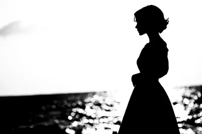 Silhouette Of A Woman Standing By The Sea