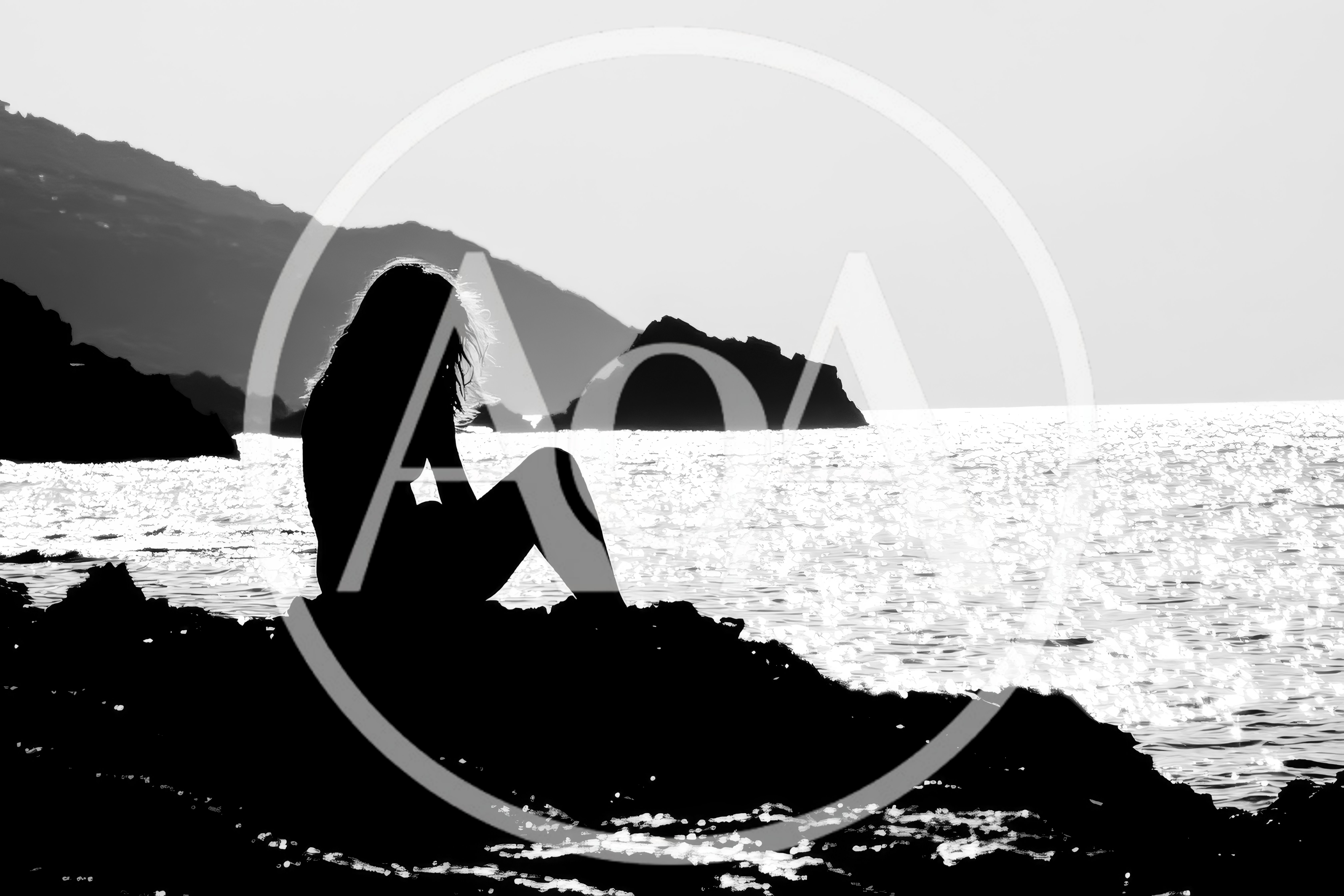 Silhouette Of A Woman Sitting On Coastal Rocks