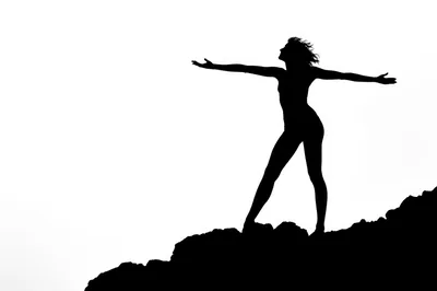Silhouette Of A Woman Standing With Arms Outstretched