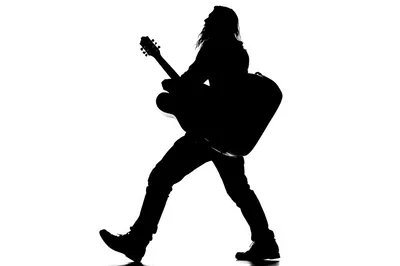 Silhouette Of A Musician Walking While Playing Acoustic Guitar