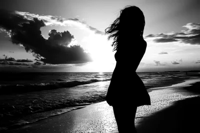 Silhouette Of A Woman Standing On A Beach