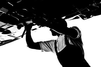 Mechanic Working Underneath A Car Chassis