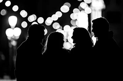 Silhouettes Of Four Friends Conversing At Night