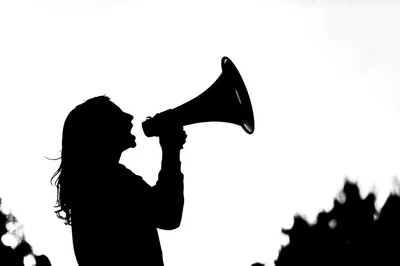 Silhouette Of A Woman Using A Megaphone