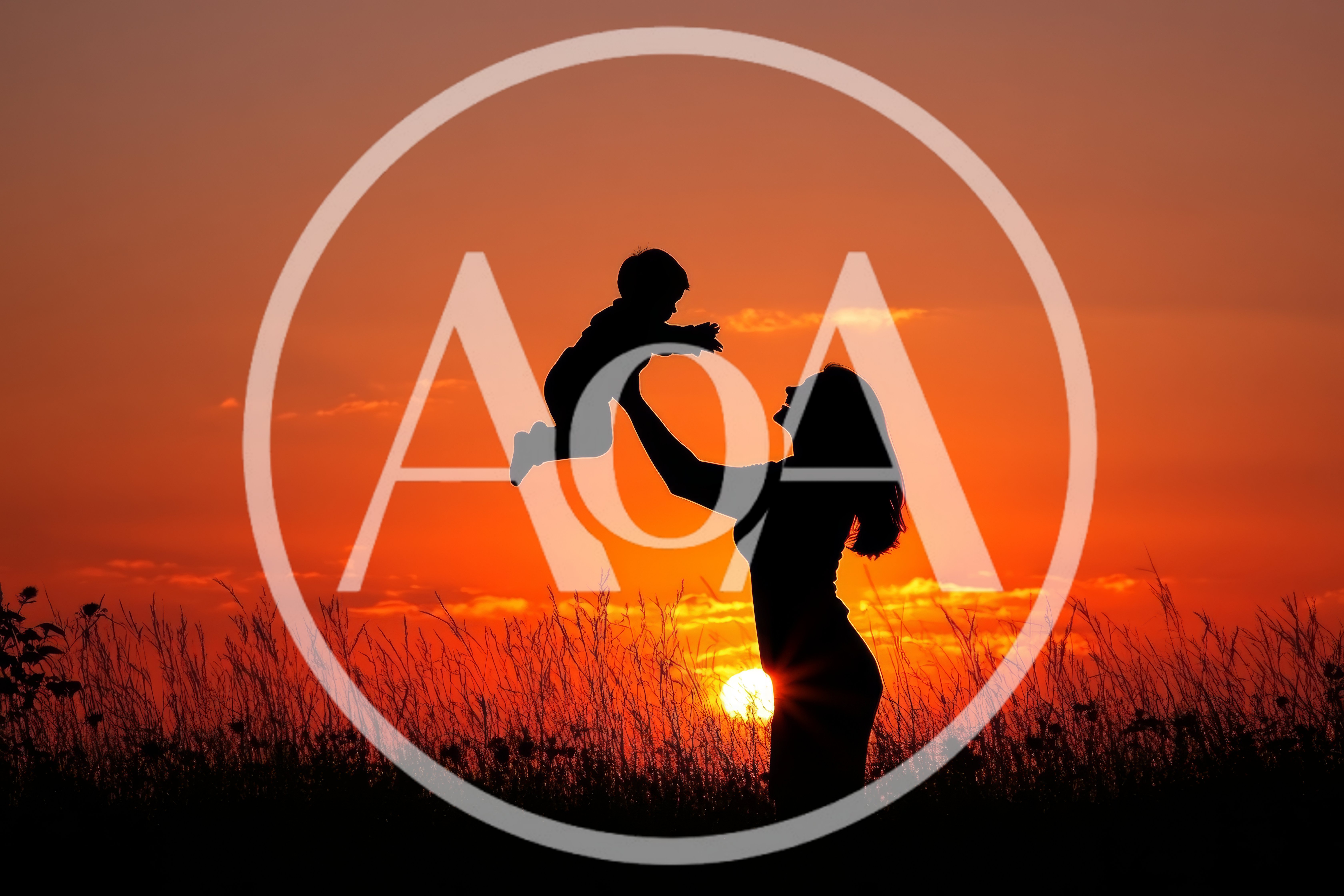 Mother Lifting Her Baby Against A Vibrant Sunset