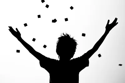 Silhouette Of A Child Throwing Confetti In The Air