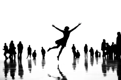 Silhouette Of A Woman Jumping Among A Crowd